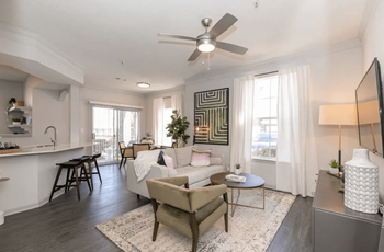A living room with a white couch and a ceiling fan at Deerfield Village, GA, 30004